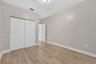Room featuring wood-finish flooring, neutral wall paint, and a sliding-door closet