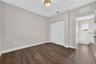 Room featuring wood-finish flooring, a double-panel sliding closet, and a neutral-toned ceiling light fixture