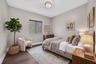 Wood-finish flooring, neutral wall tones, multi-band window shade, and flush-mount rattan light fixture