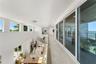 Open-concept upper level featuring large-format tile flooring, a multi-story glass pendant chandelier, expansive floor-to-ceiling sliding glass doors,