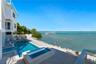 Waterfront property featuring an in-ground swimming pool, integrated spa, paved stone deck, and a private boat dock