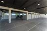 Covered parking area featuring large-format concrete pavers with stone aggregate borders, structural support pillars, white privacy screening, and rec