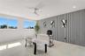 Room featuring large windows, neutral stone-finish flooring, recessed lighting, a modern ceiling fan, and a decorative vertical-slat accent wall
