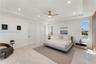Tray ceiling featuring recessed lighting, a central ceiling fan, large-format tile flooring, and floor-to-ceiling wood-finish cabinetry
