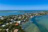 Aerial coastal perspective featuring direct water frontage, an expansive private dock, and surrounding tropical vegetation