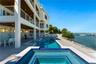 Multi-level exterior featuring tiered balconies with metal railings, a covered patio with recessed lighting, an integrated swimming pool and spa, and 