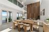 Double-height living area featuring floor-to-ceiling wood paneled accent wall with integrated linear lighting, glass-railed mezzanine, contemporary mu