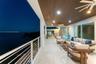 Covered balcony featuring a slatted wood-finish ceiling, large-format tile flooring, recessed lighting, ceiling fans, and a horizontal cable railing s