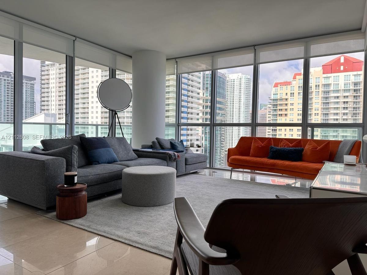 Floor-to-ceiling windows, ceramic tile flooring, and a structural column