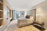Custom built-in light wood cabinetry, recessed ceiling lighting, and glass sliding doors leading to an exterior balcony