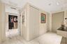 Large-format tile flooring, built-in floor-to-ceiling cabinetry with panel detailing, and custom walk-in closet featuring wood-finish shelving and dra