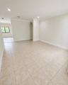Neutral-toned tile flooring, recessed ceiling lighting, crown molding, and a distinctive arched architectural feature