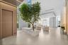 Open-concept interior featuring vertical wood-slat wall paneling, floor-to-ceiling windows, large-format tile flooring, and a built-in stone planter