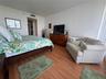 Wood-finish flooring throughout, neutral wall color, and floor-to-ceiling window treatment