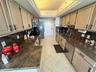 Kitchen featuring light-finish cabinetry with matte black hardware, stone-finish countertops, stainless steel appliances, and neutral tile flooring