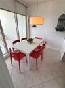 Neutral tile flooring, floor-to-ceiling glass sliding doors, and a cylindrical pendant light fixture
