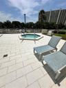 Elevated terrace featuring a paved stone deck, an in-ground spa, and a perimeter safety railing
