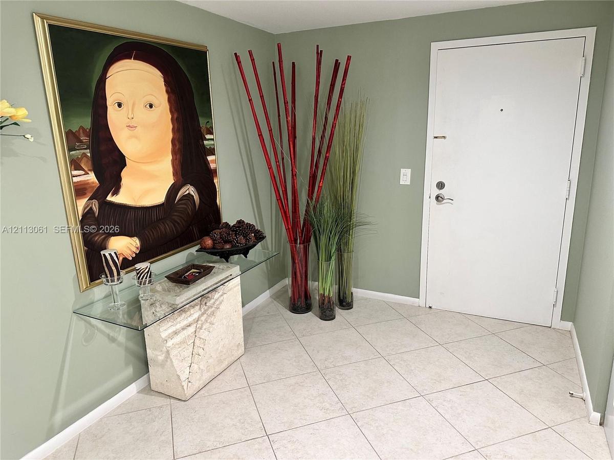 Entryway featuring light-colored diagonal floor tile and a solid-panel door