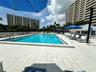 Swimming pool with tiled decking and metal perimeter fencing