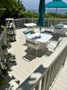 Elevated deck featuring composite plank flooring, white vertical balustrade railing, and an expansive ocean backdrop