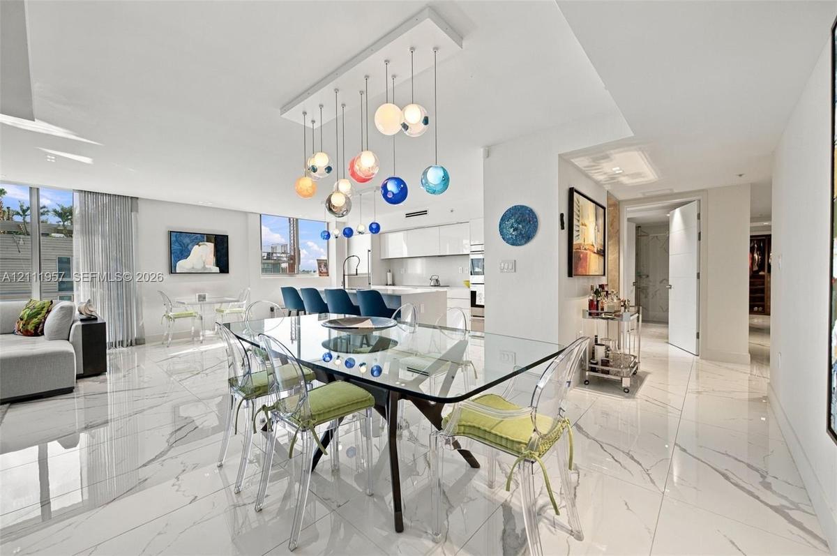 Large format tile flooring with high-gloss finish, multi-colored tiered glass globe chandelier, expansive floor-to-ceiling windows, and minimalist kit