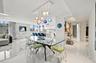 Large format tile flooring with high-gloss finish, multi-colored tiered glass globe chandelier, expansive floor-to-ceiling windows, and minimalist kit