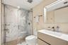 Floating vanity with integrated rectangular sink and metallic faucet, complemented by a walk-in shower featuring sliding glass doors and large-format 