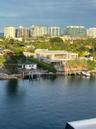 Waterfront property featuring private dockage, concrete seawall, mature perimeter landscaping, and multi-level structural design