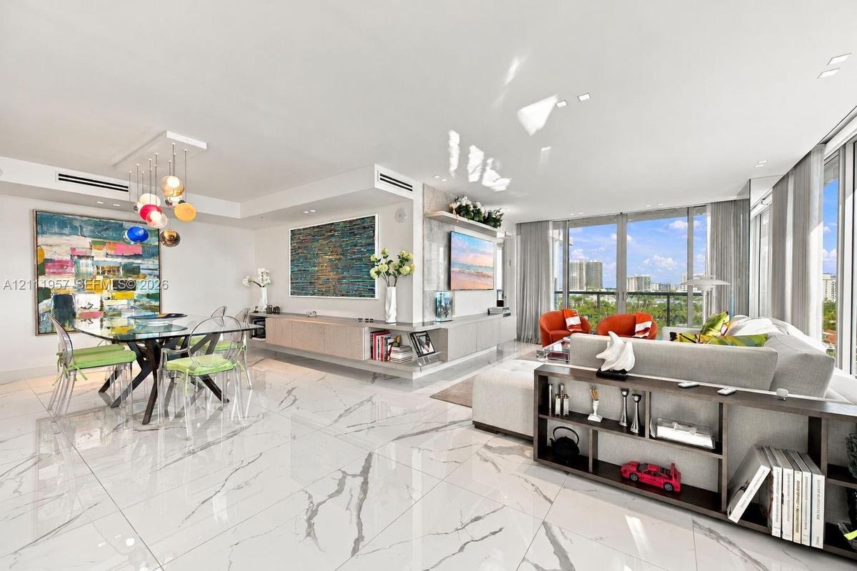 Open-concept living space featuring large-format veined tile flooring, built-in recessed cabinetry, floor-to-ceiling windows, and recessed lighting