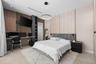 Custom built-in wood-slat desk station with integrated shelving, recessed ceiling lighting, circular pendant light fixture, and dual-tone wall panelin