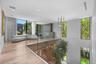 Open-concept floor plan featuring wood-finish flooring, floor-to-ceiling windows, a glass panel railing, and integrated linear lighting