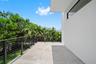 Covered balcony featuring concrete flooring, horizontal cable railing, and stucco exterior finish