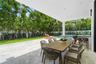 Covered outdoor patio featuring large-format stone tiling, integrated recessed lighting, a built-in outdoor bar with countertop, an in-ground swimming