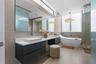 Floating dual-vanity with rectangular vessel sinks, quartz countertop, wall-mounted faucets, freestanding soaking tub, and glass-enclosed shower with 