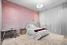 Room featuring large-scale illustrated wall covering, neutral wood-finish flooring, floor-to-ceiling drapery, and a textured pendant light fixture