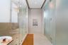 Walk-in shower featuring a glass enclosure, floor-to-ceiling frosted glass partitioning, recessed ceiling lighting, wall-mounted heated towel rack, an
