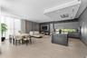 Open-concept interior featuring large-format tile flooring, a kitchen island with stone surfacing, matte-finish cabinetry, recessed ceiling lighting, 