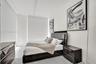 Light-toned wood-finish flooring and expansive floor-to-ceiling windows with roller shades
