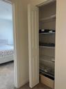 Storage closet featuring white bifold doors and integrated wire shelving