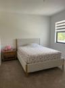 Neutral-toned carpeted flooring, neutral wall paint, and a window featuring horizontally striped roller shades