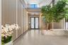 Double-height foyer featuring vertical slat wall paneling with integrated recessed lighting, large-format tile flooring, a glass-railed staircase, and