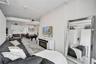 Open-concept interior featuring industrial-style exposed ductwork, white painted brick walls, wood-finish flooring, and a built-in wall-mounted electr