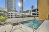 Swimming pool featuring a concrete deck, built-in metal handrails, and a dedicated wading area