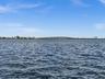 Waterfront perspective featuring open-water exposure and a distant bridge silhouette