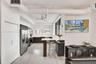 Kitchen featuring dark cabinetry, stainless steel appliances, white countertops, a breakfast bar, and wood-finish flooring