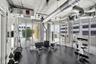 Industrial-style interior featuring exposed concrete ceilings, metallic ductwork, floor-to-ceiling glass wall panels, and impact-resistant rubber floo