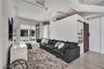 Industrial-style interior featuring high ceilings with exposed ductwork, wood-finish flooring, and a sliding barn door with matte black hardware