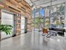 Industrial-style lobby featuring polished concrete flooring, a multi-tonal reclaimed wood accent wall, dual stainless steel elevator doors, floor-to-c