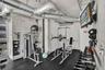 Industrial-style interior featuring exposed concrete masonry unit walls, exposed galvanized steel ductwork, and black rubberized flooring