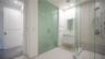 Bathroom featuring a floating vanity with a vessel sink, a walk-in shower with a glass enclosure, a rainfall showerhead, and a frosted-glass door
